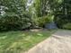 Serene backyard featuring mature trees, greenery, a storage shed, and ample space at 3110 Fieldstone Ln, Mebane, NC 27302