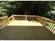 A wooden deck with natural wood railings in a backyard at 3110 Fieldstone Ln, Mebane, NC 27302