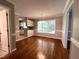 Bright dining room featuring hardwood floors and natural light, with a view into the kitchen at 3110 Fieldstone Ln, Mebane, NC 27302