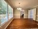Open dining room with hardwood floors, natural light, and a view into the living room with fireplace at 3110 Fieldstone Ln, Mebane, NC 27302