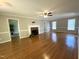 Bright living room featuring hardwood floors, a fireplace, and large windows at 3110 Fieldstone Ln, Mebane, NC 27302