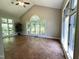 Open sunroom with vaulted ceilings, brick floors, and large windows overlooking the wooded backyard at 3110 Fieldstone Ln, Mebane, NC 27302