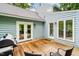 Spacious wood back deck featuring outdoor furniture, a grill, and glass doors to the interior of the home at 318 Fieldstone Dr, Burlington, NC 27215
