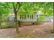 Backyard view of the home with a brick-lined patio and deck overlooking the serene landscape at 318 Fieldstone Dr, Burlington, NC 27215