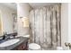 Cozy bathroom showcasing dark vanity, decorative mirror, and shower with patterned curtain at 318 Fieldstone Dr, Burlington, NC 27215