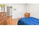 Neutral bedroom featuring hardwood floors, double closets, and a glimpse into another room at 318 Fieldstone Dr, Burlington, NC 27215