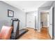 Well-lit bedroom with hardwood floors, treadmill, and a double door closet for ample storage at 318 Fieldstone Dr, Burlington, NC 27215