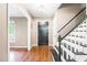 Inviting foyer featuring hardwood floors, staircase with black and white accents, and black front door at 318 Fieldstone Dr, Burlington, NC 27215