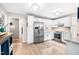 Spacious kitchen with stainless steel refrigerator, white cabinetry, and light wood flooring at 318 Fieldstone Dr, Burlington, NC 27215