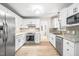 Well-lit kitchen featuring stainless steel appliances, white cabinets, and neutral countertops at 318 Fieldstone Dr, Burlington, NC 27215