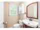 Charming powder room featuring a wooden vanity, toilet, and window with natural light at 318 Fieldstone Dr, Burlington, NC 27215