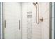 Modern shower features sleek, white tiled walls, decorative mosaic inset, and glass door at 318 Fieldstone Dr, Burlington, NC 27215