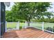 Lovely backyard deck with white railings and a large shade tree at 4005 Olde Waverly Way, Fuquay Varina, NC 27526