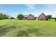 Spacious backyard with a well-kept lawn and brick home with an adjacent garage at 4005 Olde Waverly Way, Fuquay Varina, NC 27526