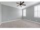 This bedroom features a ceiling fan and two windows with modern white shutters for natural light at 4005 Olde Waverly Way, Fuquay Varina, NC 27526