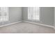 This bedroom offers neutral walls, plush carpeting, and great natural light from two windows with modern white shutters at 4005 Olde Waverly Way, Fuquay Varina, NC 27526