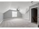 A bonus room with plush carpeting, a ceiling fan and a window with modern white shutters for natural light at 4005 Olde Waverly Way, Fuquay Varina, NC 27526