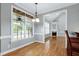 Bright dining room featuring hardwood floors, a large window, and an open view to a fireplace at 4005 Olde Waverly Way, Fuquay Varina, NC 27526