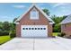 Beautiful brick detached garage with a white carriage door and an arched window under a blue sky at 4005 Olde Waverly Way, Fuquay Varina, NC 27526