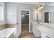 Bright bathroom featuring a double vanity, soaking tub, and doorway to a bedroom at 4005 Olde Waverly Way, Fuquay Varina, NC 27526