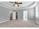 Large main bedroom with tray ceilings, ceiling fan, and access to ensuite bathroom at 4005 Olde Waverly Way, Fuquay Varina, NC 27526