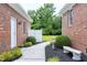 Charming walkway between brick buildings, featuring lush landscaping, a birdbath, and a stone bench at 4005 Olde Waverly Way, Fuquay Varina, NC 27526