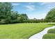 Beautifully landscaped yard with mature trees and a pristine lawn at 4005 Olde Waverly Way, Fuquay Varina, NC 27526