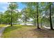 Picturesque view of backyard with lush green grass leading to lake at 405 Commons Walk Cir, Cary, NC 27519