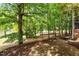 Lush backyard with shade trees and large brick paver patio at 405 Commons Walk Cir, Cary, NC 27519