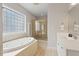 Bathroom with tiled floors, a large soaking tub, separate shower, and bright lighting at 405 Commons Walk Cir, Cary, NC 27519