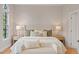 Bright bedroom featuring a tufted headboard, stylish decor, and a charming arched window at 405 Commons Walk Cir, Cary, NC 27519