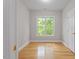 Bright bedroom featuring a large window with lush green views and hardwood flooring at 405 Commons Walk Cir, Cary, NC 27519