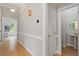 Inviting hallway with hardwood floors, modern lighting, and access to a powder room at 405 Commons Walk Cir, Cary, NC 27519