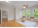 Bright living room with hardwood floors, multiple windows, and a cozy seating area at 405 Commons Walk Cir, Cary, NC 27519