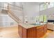 View from staircase to kitchen and living room with fireplace and hardwood floors at 405 Commons Walk Cir, Cary, NC 27519