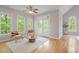Sunlit living room with hardwood floors, multiple windows, and stylish decor at 405 Commons Walk Cir, Cary, NC 27519