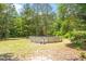 Backyard view featuring an above-ground pool, surrounded by mature trees at 462 Sullivan Rd, Selma, NC 27576