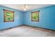 Bedroom with blue walls, carpet, two windows, and natural light at 462 Sullivan Rd, Selma, NC 27576