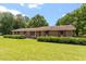Charming brick home with large windows and lush landscaping on a sunny day at 462 Sullivan Rd, Selma, NC 27576