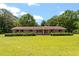Classic brick ranch-style home featuring a large, manicured lawn and mature trees at 462 Sullivan Rd, Selma, NC 27576