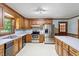 Well-lit kitchen featuring stainless steel appliances, wooden cabinetry, and white countertops at 462 Sullivan Rd, Selma, NC 27576
