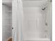 Clean bathroom featuring a shower-tub combo with new fixtures, white shower curtain, and a closet with shelving at 500 N Duke St # 55-105, Durham, NC 27701