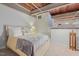 Comfortable bedroom with exposed wood ceiling, accent lighting, and stairs leading to a loft area at 500 N Duke St # 55-105, Durham, NC 27701