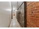 Hallway with polished concrete floors, exposed brick accent wall, and metal sliding door for a modern, industrial look at 500 N Duke St # 55-105, Durham, NC 27701