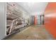 Long hallway featuring polished concrete floors, black and white architectural photography, and orange accent walls at 500 N Duke St # 55-105, Durham, NC 27701