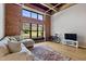 Comfortable living room with exposed brick wall, large windows, and stylish rug enhancing the space at 500 N Duke St # 55-105, Durham, NC 27701