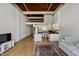 Open-concept living space featuring a modern kitchen, hardwood floors, and exposed beam ceiling at 500 N Duke St # 55-105, Durham, NC 27701