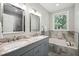Bathroom featuring double vanity, soaking tub, marble surround, and natural light at 6 Danesfield Ct, Durham, NC 27707