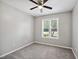 Cozy bedroom featuring neutral walls, ceiling fan, plush carpet, and a bright window at 6 Danesfield Ct, Durham, NC 27707