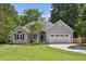 Charming one-story home with gray siding, blue shutters, manicured lawn, and attached two car garage at 6 Danesfield Ct, Durham, NC 27707